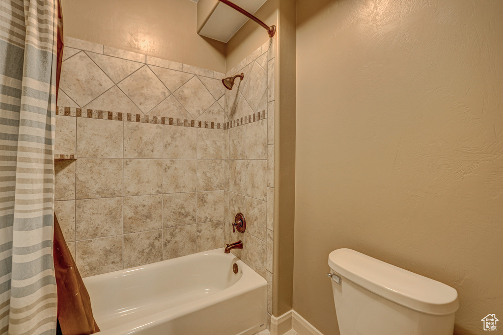 Bathroom with shower / bath combo with shower curtain and toilet