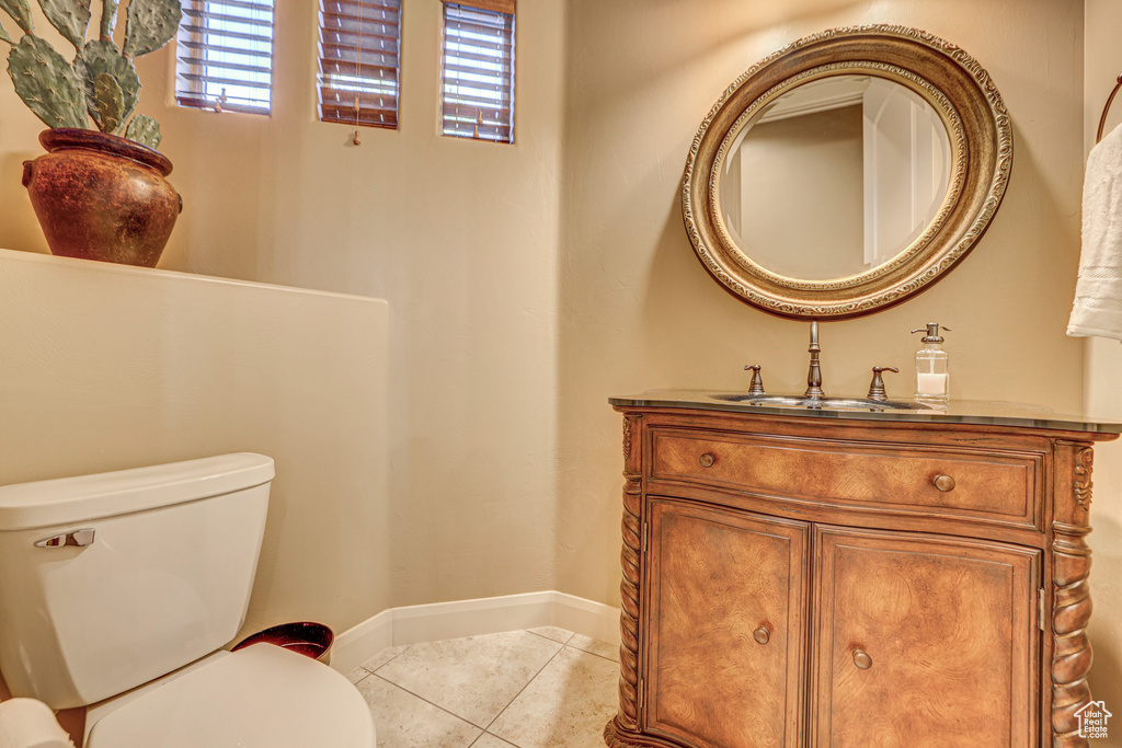 Bathroom featuring vanity, toilet, and tile patterned floors