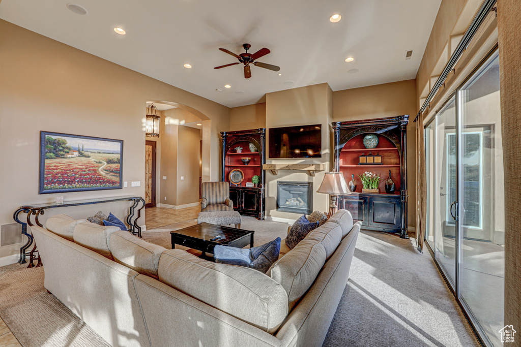 Carpeted living room featuring ceiling fan