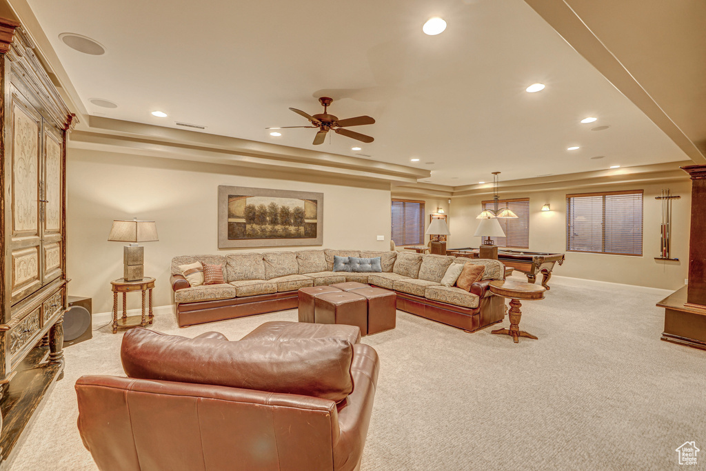 Carpeted living room with ceiling fan, billiards, and a tray ceiling