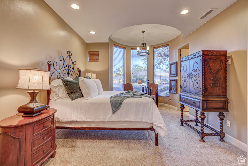 Carpeted bedroom with a notable chandelier