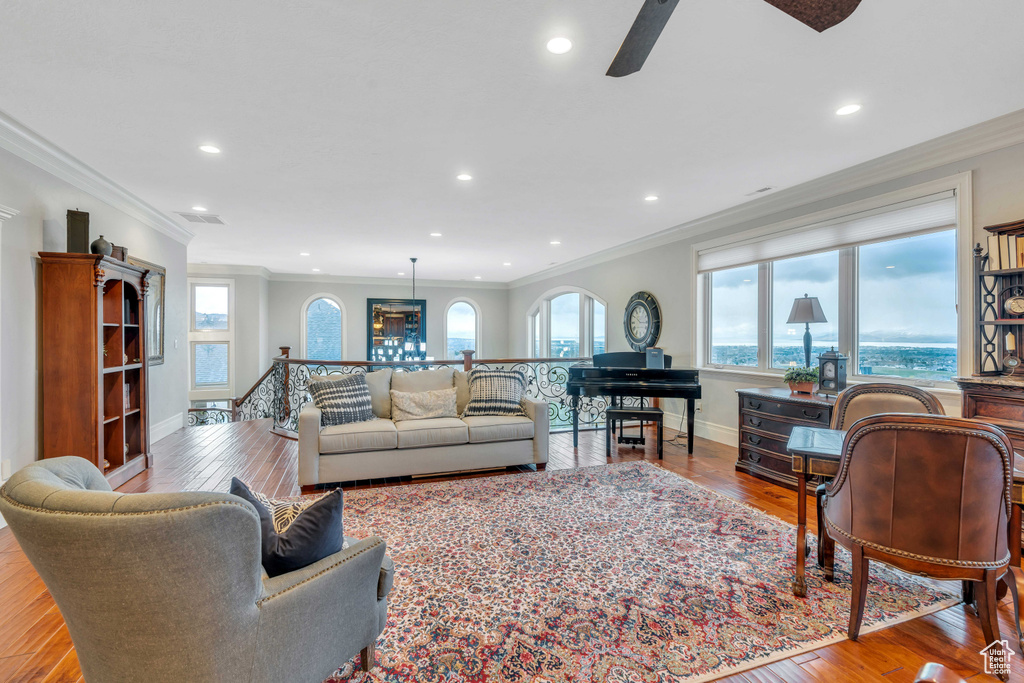 Living room featuring ceiling fan, light wood-type flooring, and ornamental molding