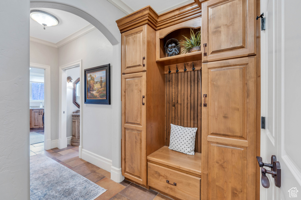 Mudroom with crown molding and tile patterned floors