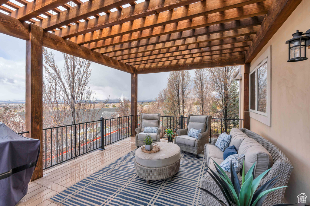 Wooden deck featuring a pergola, area for grilling, and an outdoor hangout area