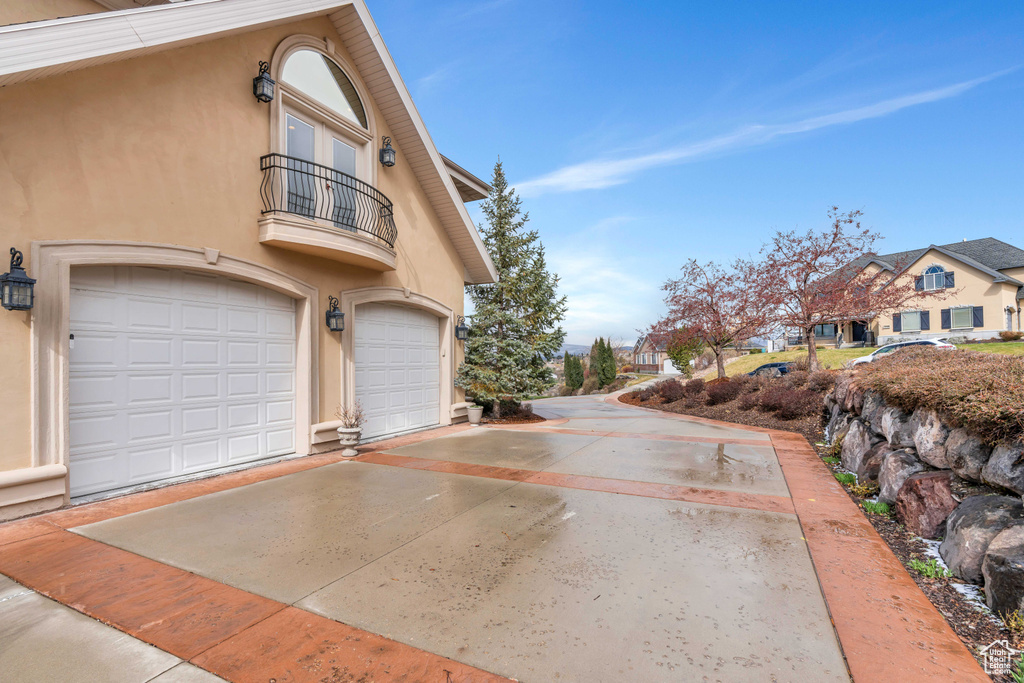 View of property exterior with a balcony and a garage