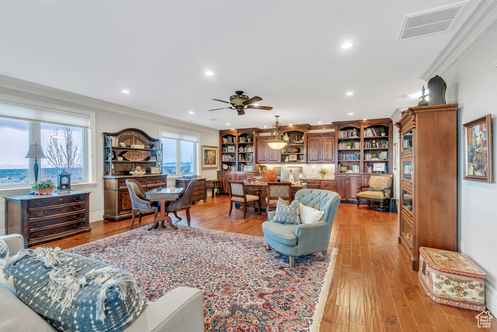 Living room with crown molding, light hardwood / wood-style floors, and ceiling fan