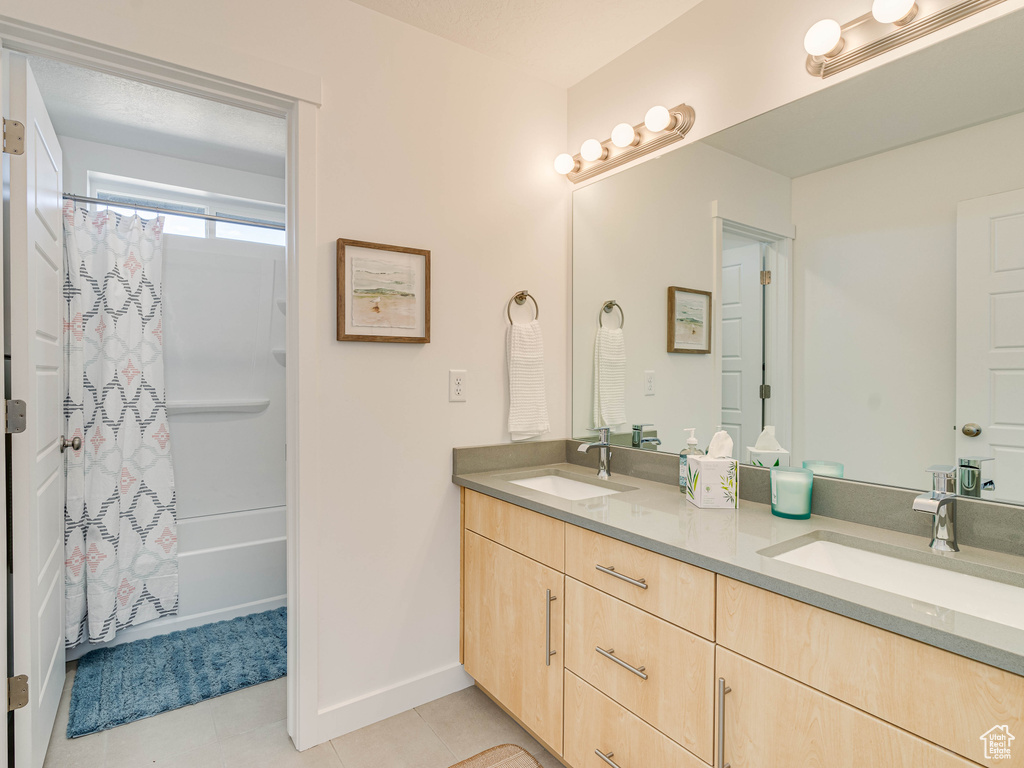 Bathroom featuring tile patterned flooring, vanity, and shower / bath combo with shower curtain