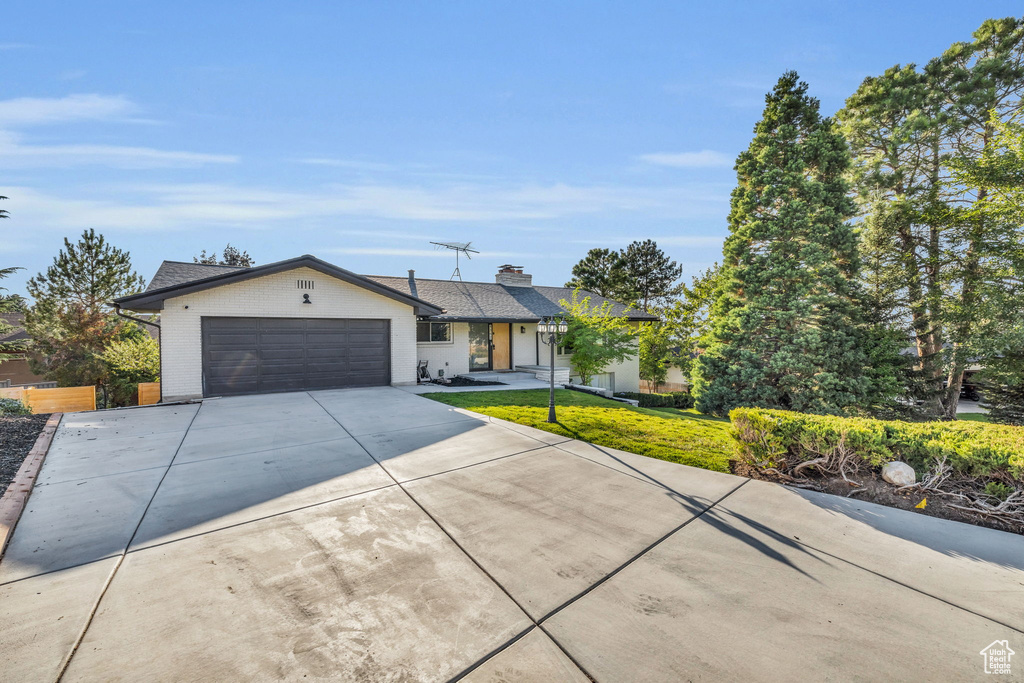 Ranch-style home with a front yard and a garage