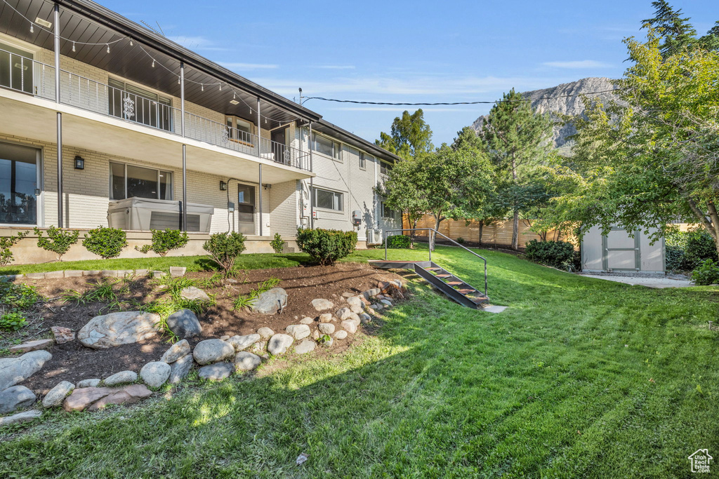 View of yard featuring a balcony and an outdoor structure