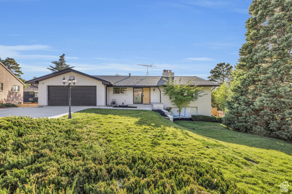 Single story home with a front yard and a garage