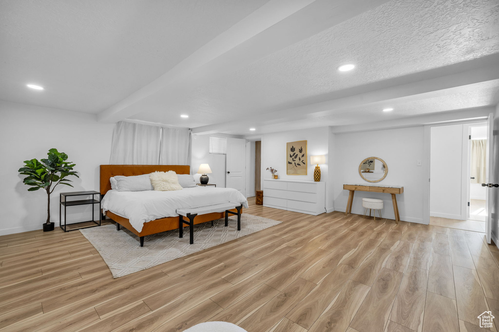 Bedroom with a textured ceiling and light hardwood / wood-style flooring