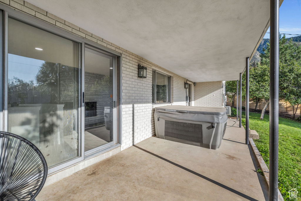 View of patio with a hot tub