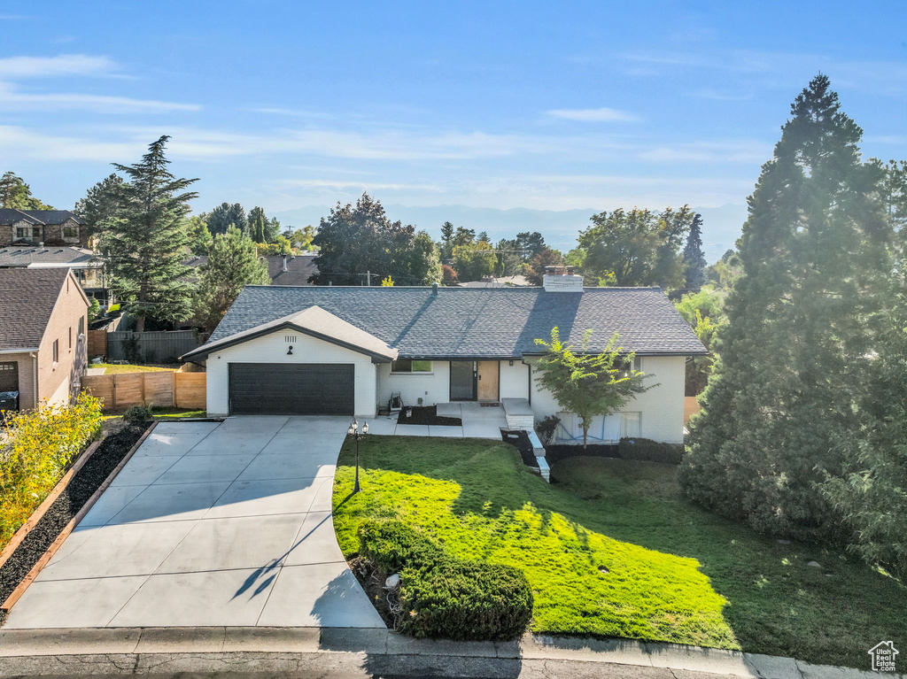 View of front of property featuring a front lawn and a garage