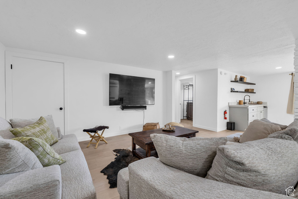 Living room with light hardwood / wood-style flooring and sink