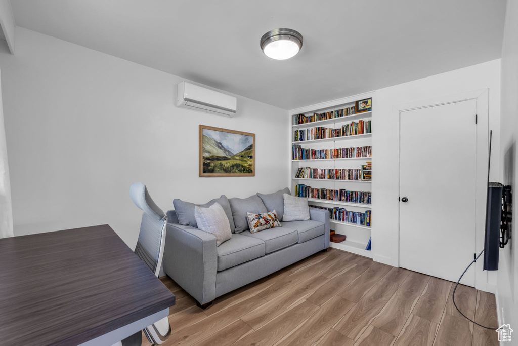 Living room featuring a wall mounted AC and hardwood / wood-style flooring