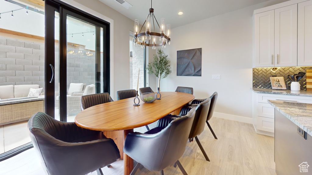 Dining space featuring a chandelier and light hardwood / wood-style floors