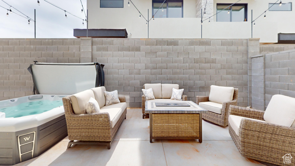 View of patio with an outdoor living space with a fire pit and a hot tub