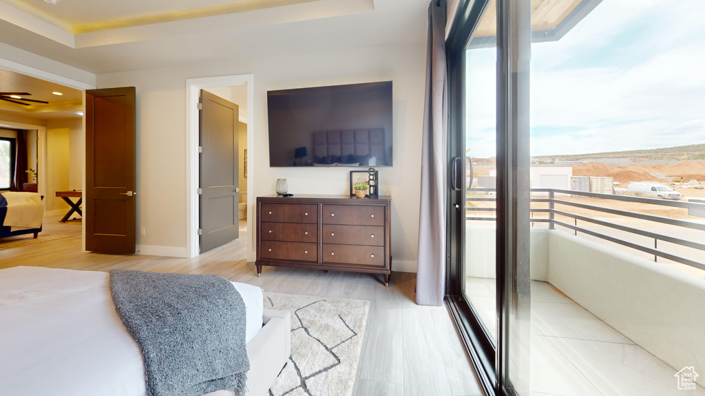 Bedroom featuring light wood-type flooring and a raised ceiling