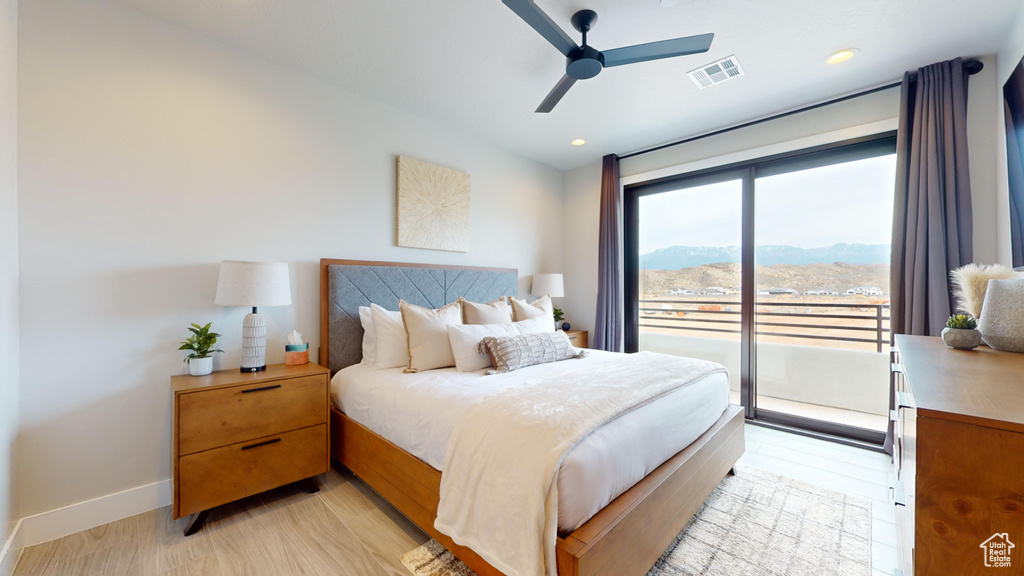 Bedroom featuring light hardwood / wood-style flooring, a mountain view, ceiling fan, and access to exterior