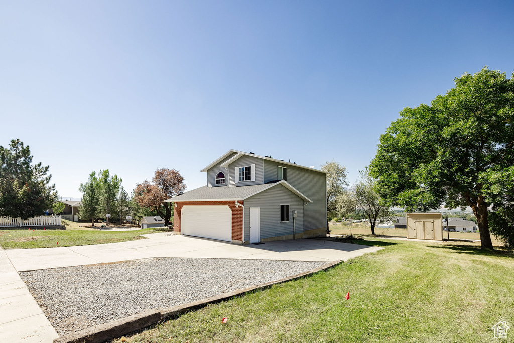 View of home\\\\\\\\\\\\\\\\\\\\\\\\\\\\\\\'s exterior with a lawn, a shed, and a garage