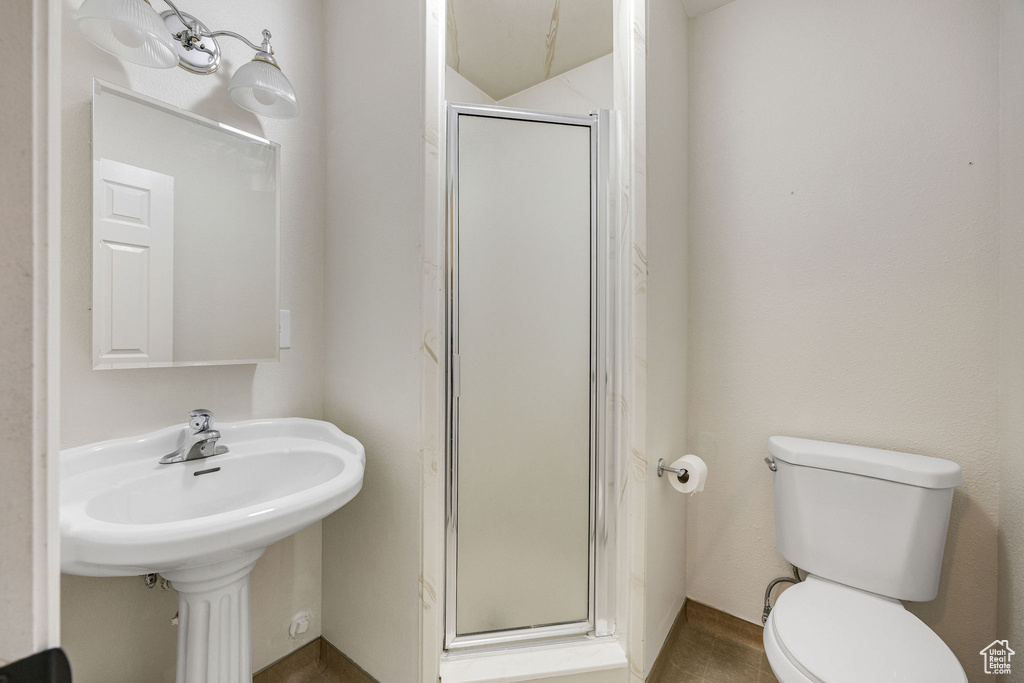 Bathroom with a shower with shower door and toilet