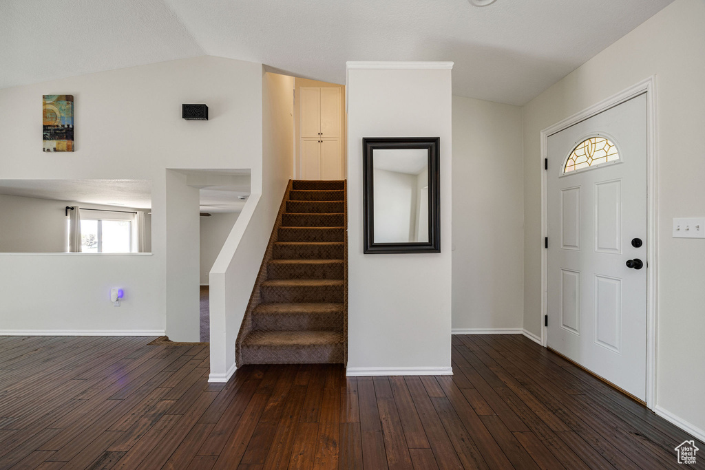 Entrance foyer with vaulted ceiling and dark wood-type flooring
