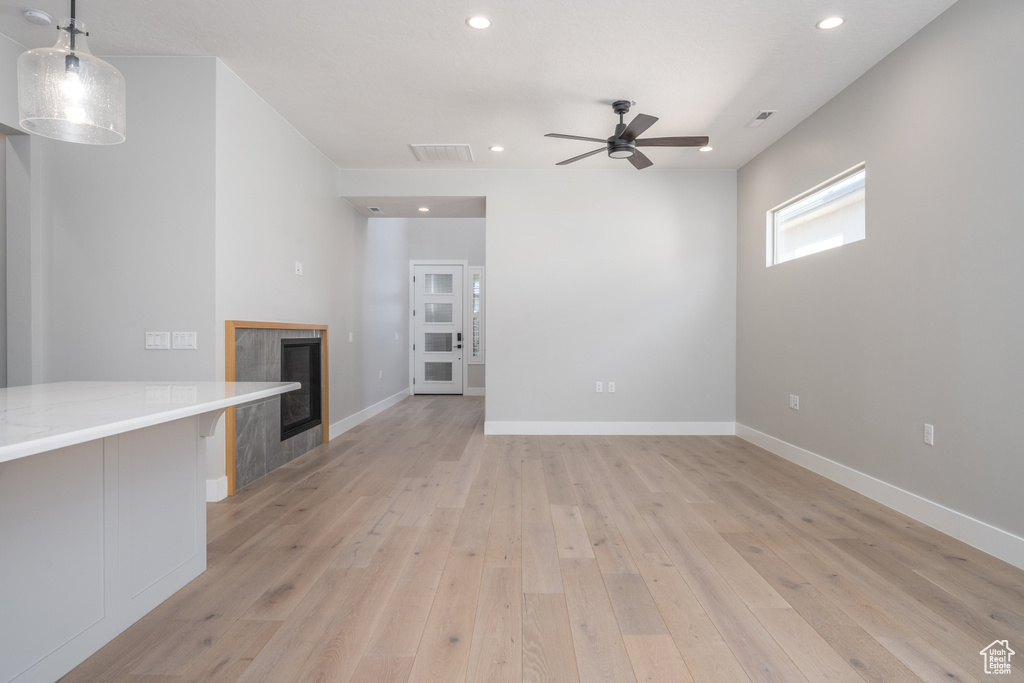 Unfurnished living room with light hardwood / wood-style flooring and ceiling fan