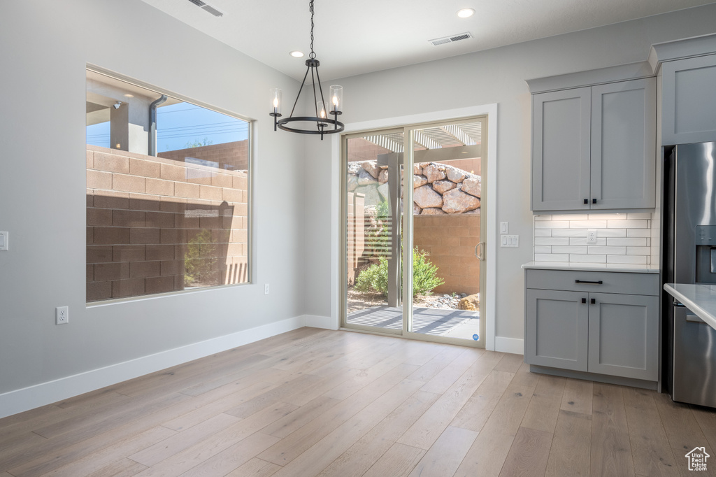 Kitchen featuring gray cabinetry, a healthy amount of sunlight, and stainless steel fridge