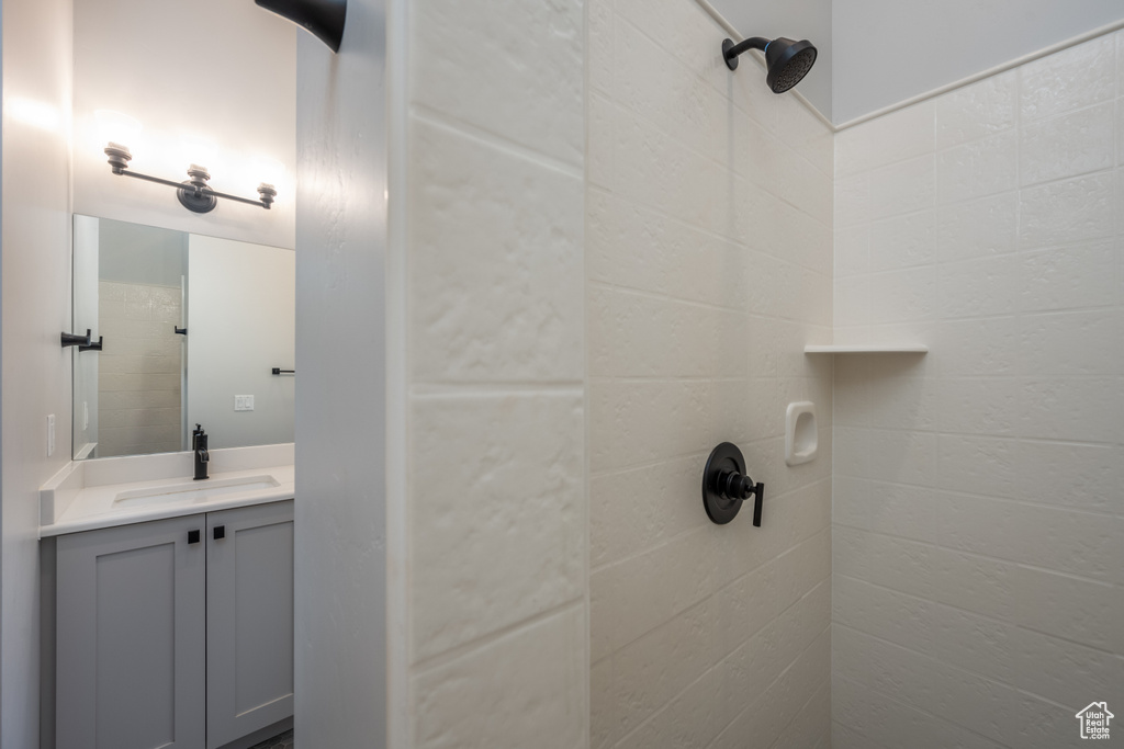 Bathroom with tiled shower and vanity