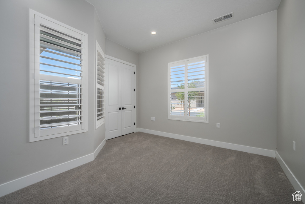 Unfurnished room featuring dark carpet