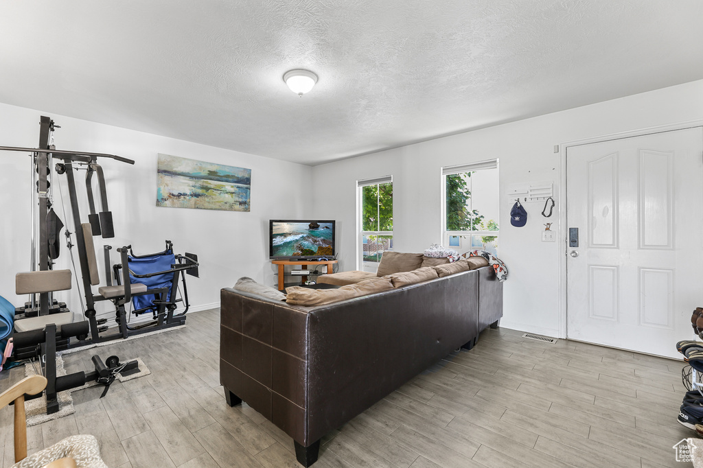 Living room with light wood-type flooring and a textured ceiling