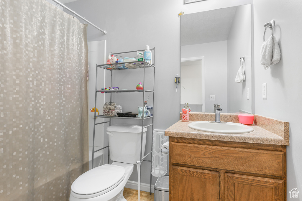 Full bathroom featuring shower / tub combo with curtain, vanity, and toilet