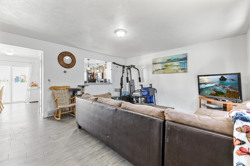 Living room featuring a textured ceiling and light hardwood / wood-style floors