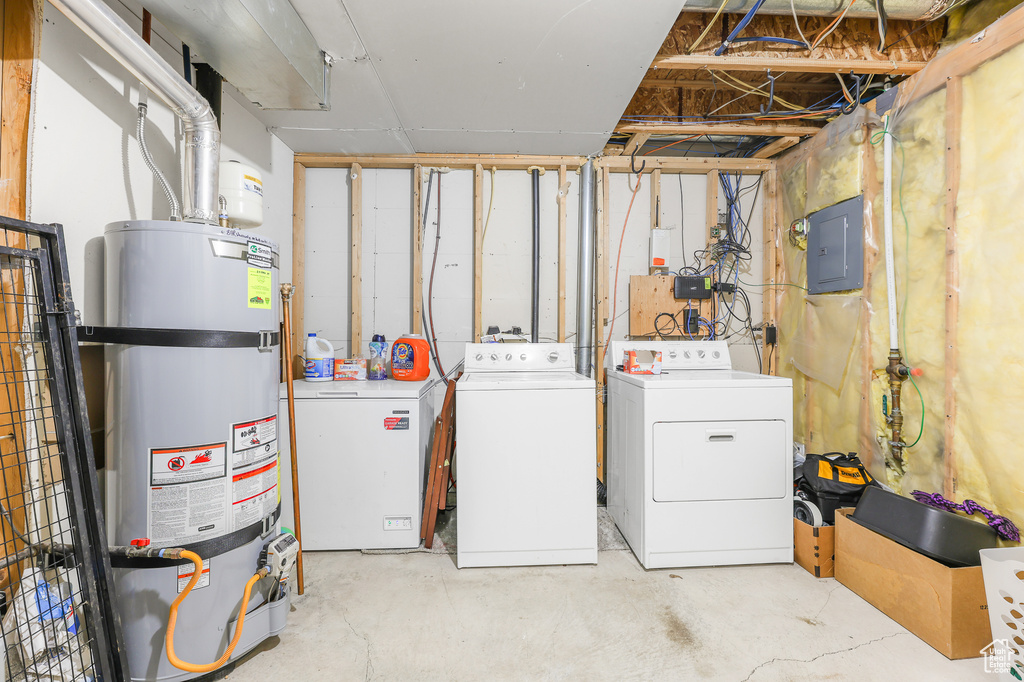 Interior space featuring washer and clothes dryer, fridge, electric panel, and secured water heater