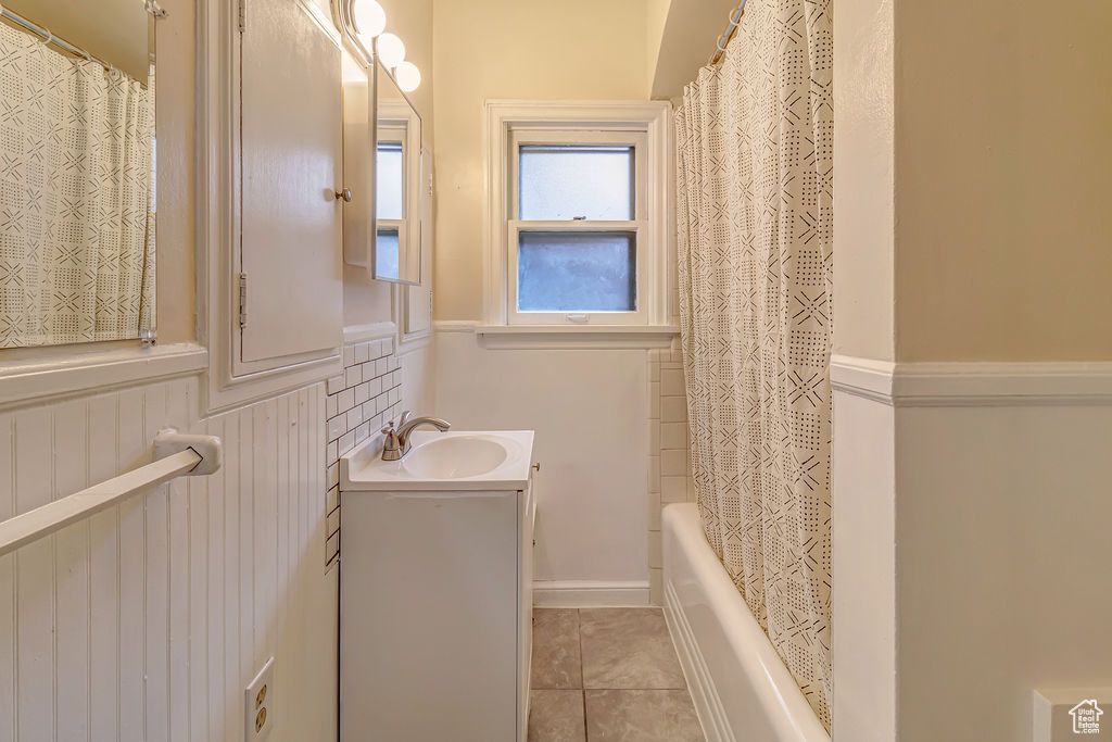 Bathroom with tile patterned flooring, vanity, and shower / bath combination with curtain