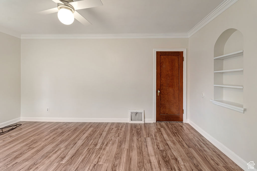 Unfurnished room featuring ceiling fan, light hardwood / wood-style flooring, and ornamental molding