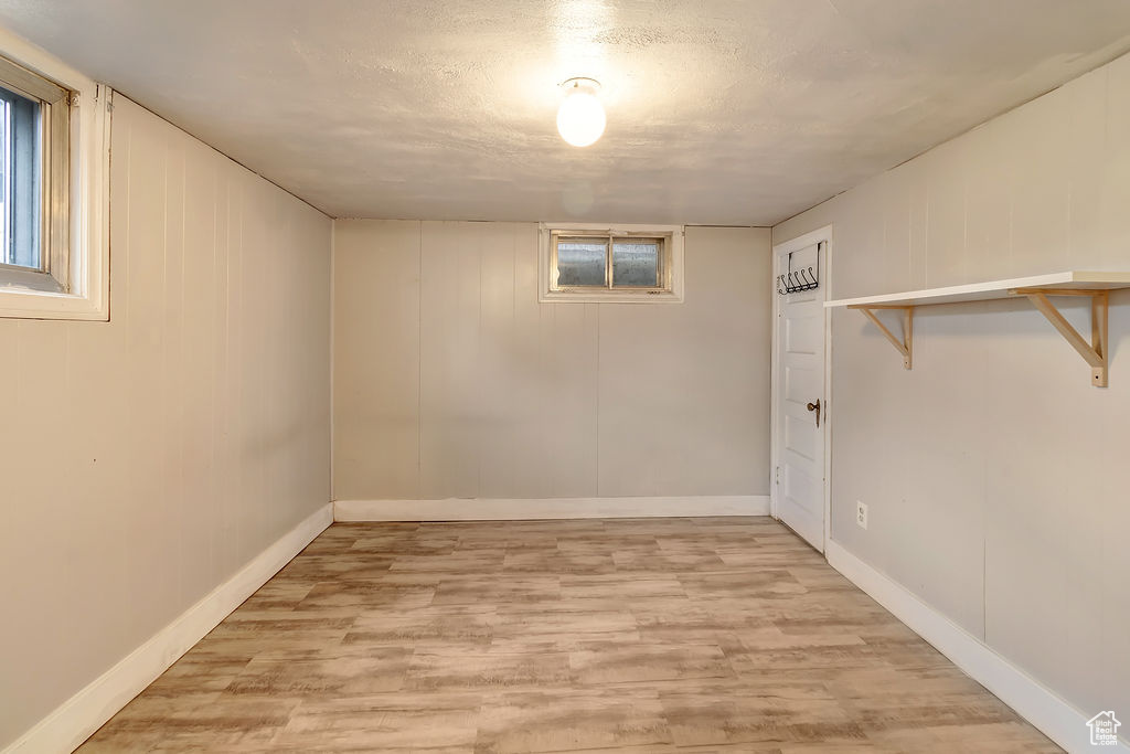 Basement featuring light hardwood / wood-style flooring and a textured ceiling