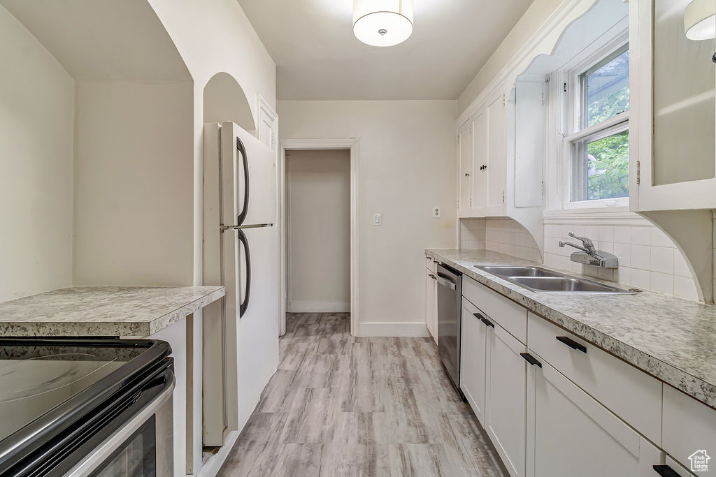 Kitchen with white cabinets, tasteful backsplash, and sink