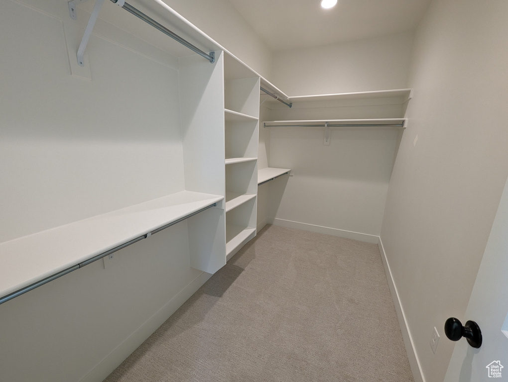 Walk in closet with light carpet