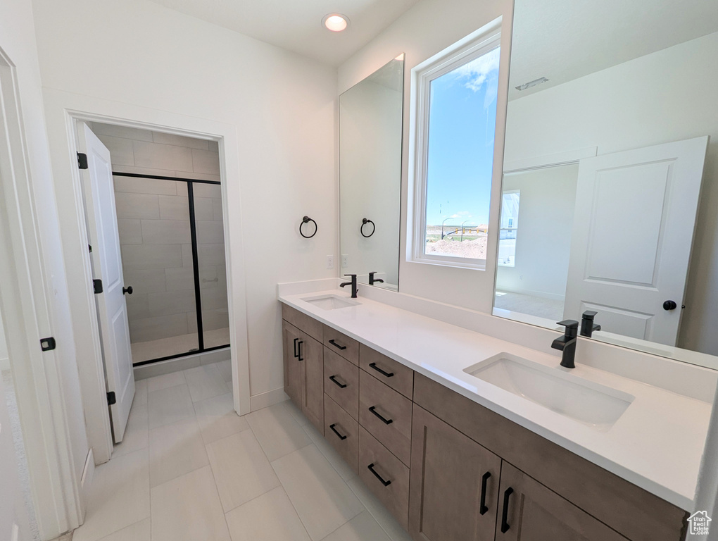 Bathroom featuring tile patterned flooring, vanity, and an enclosed shower