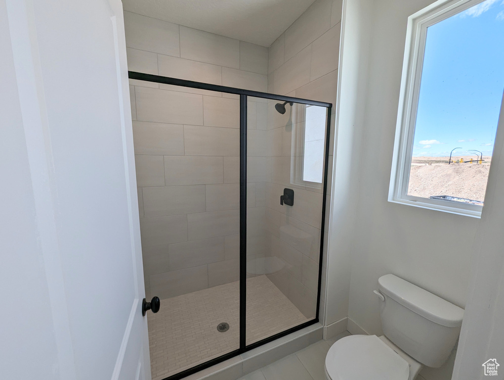 Bathroom featuring walk in shower, toilet, and tile patterned floors