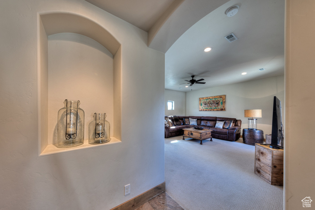Carpeted living room with ceiling fan