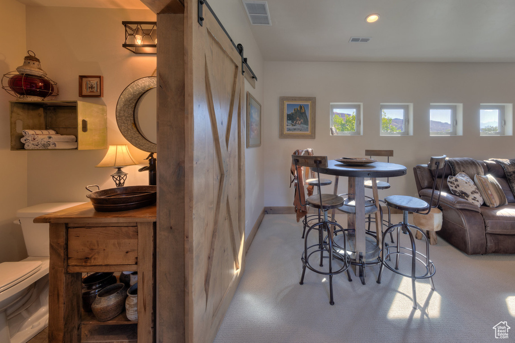 Carpeted dining space with a barn door
