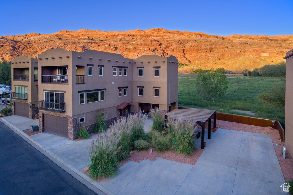 View of front of house with a balcony, a garage, and a mountain view