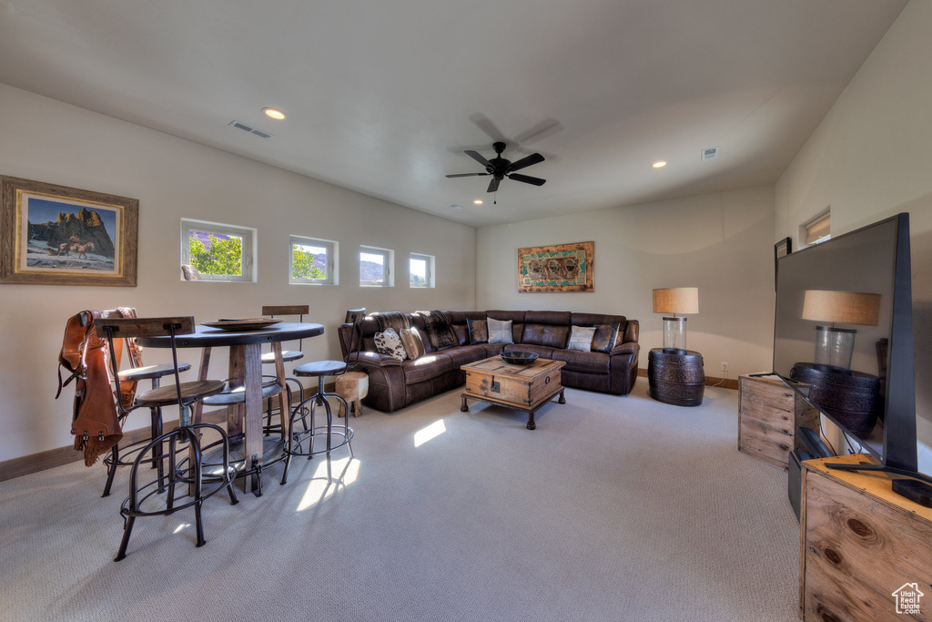 Carpeted living room with ceiling fan