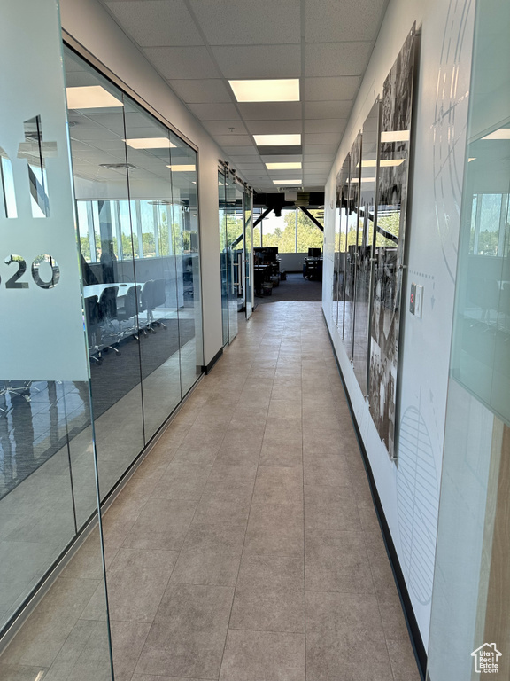 Corridor featuring expansive windows and a paneled ceiling