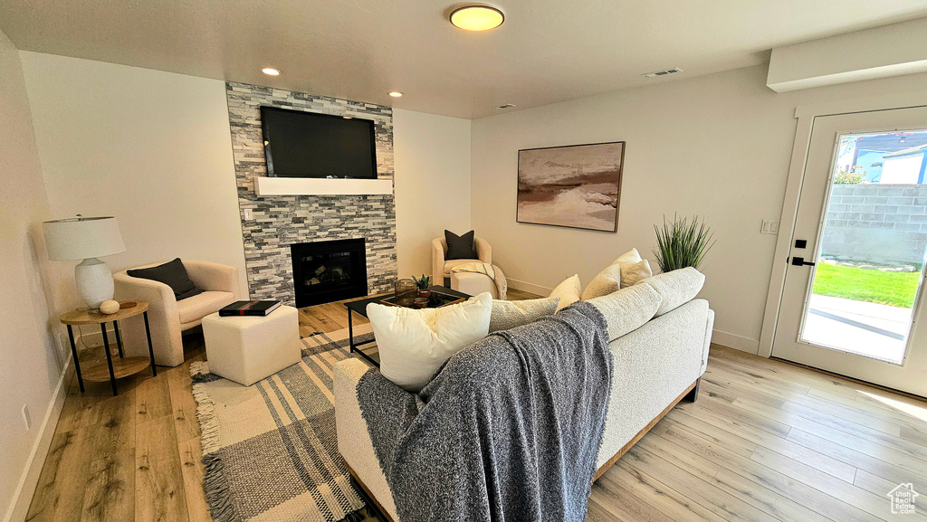 Living room with light wood-type flooring and a fireplace