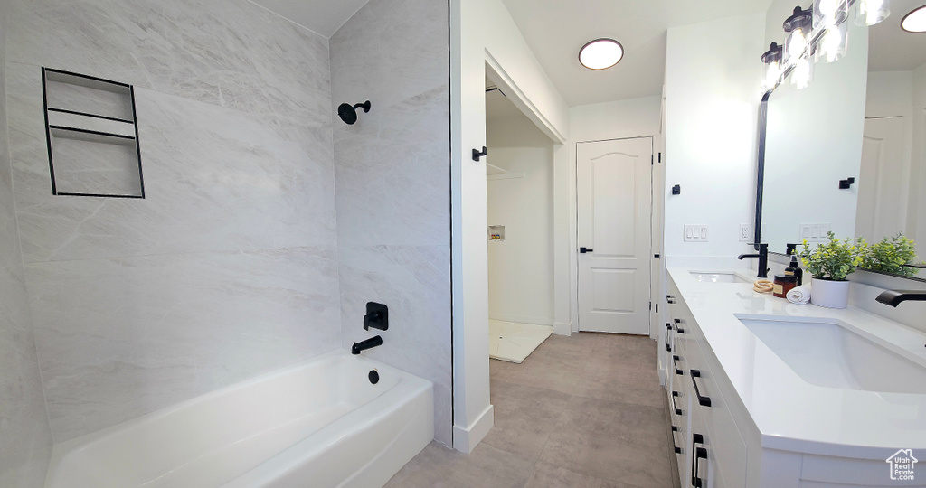 Bathroom featuring tiled shower / bath combo, tile patterned flooring, and vanity