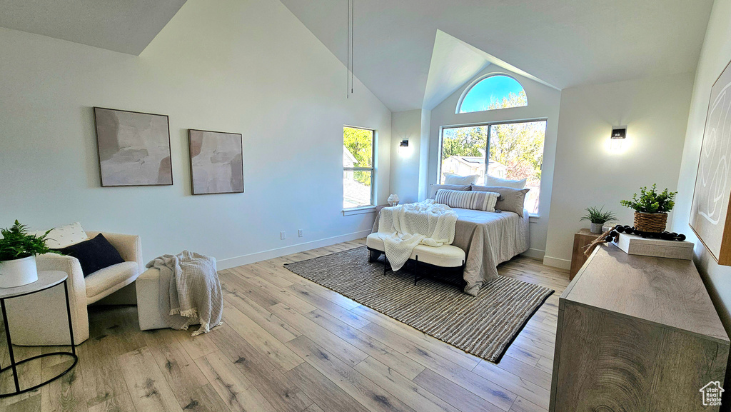 Bedroom with light hardwood / wood-style flooring and high vaulted ceiling