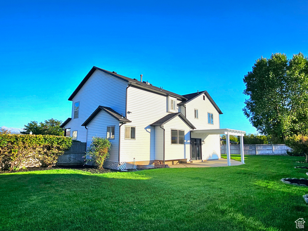 Rear view of house featuring a yard and a patio